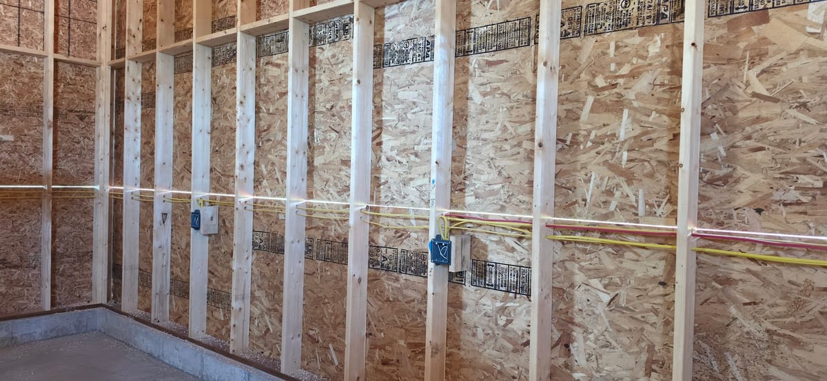 Rough-in wiring stapled through studs with device boxes set to depth, ready for inspection and drywall.
