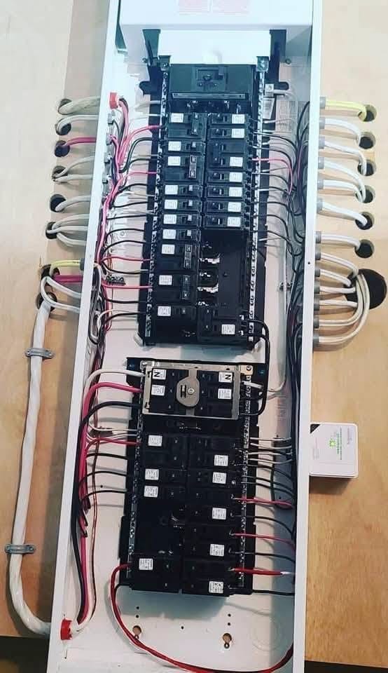 A panel with service conductors dressed and terminated on the main lugs.