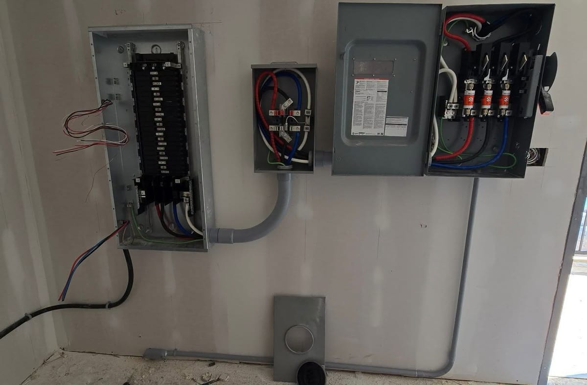 A panel and fused disconnect mounted together on an interior wall.