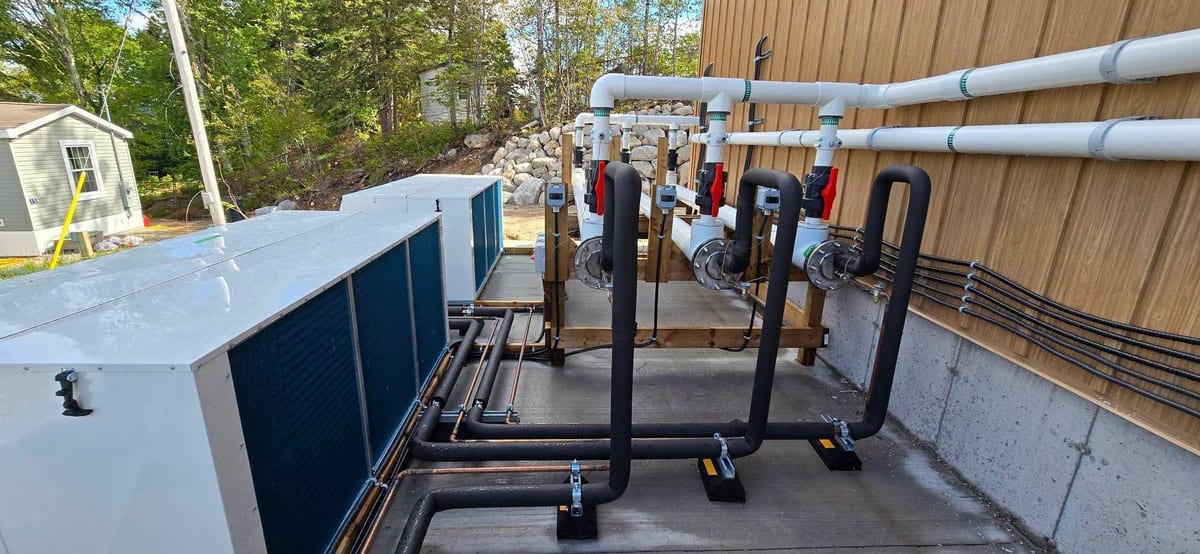 Rooftop mechanical equipment and process piping with electrical feeds run alongside.