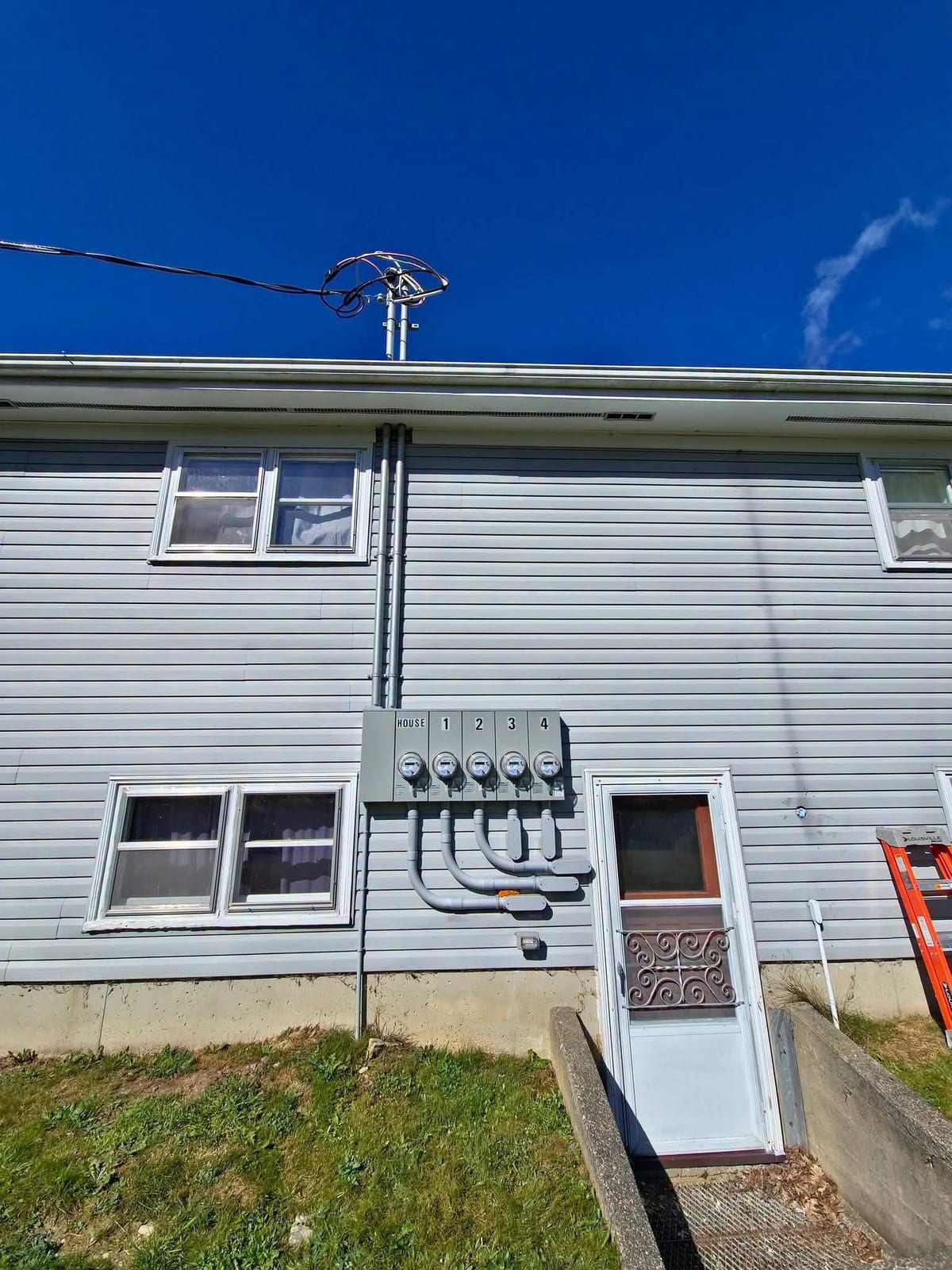 A new overhead service mast, meter base and mast head on the gable end of a house in Southwest Nova Scotia.