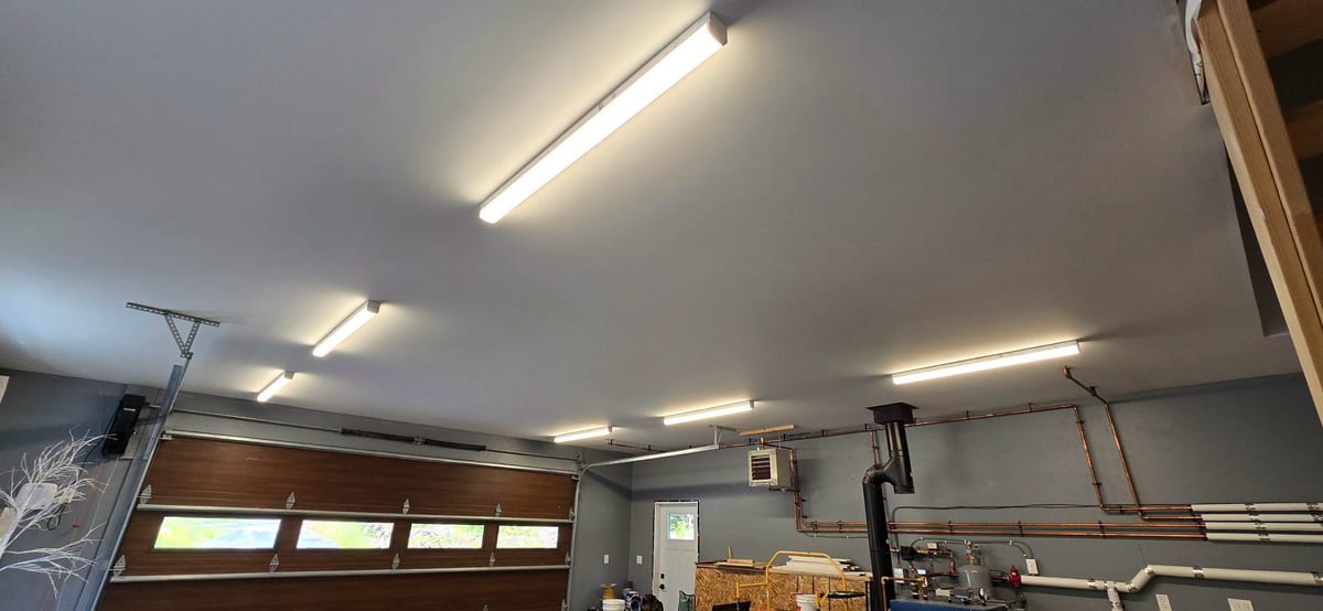 A shop interior lit by surface-mounted linear LED fixtures.